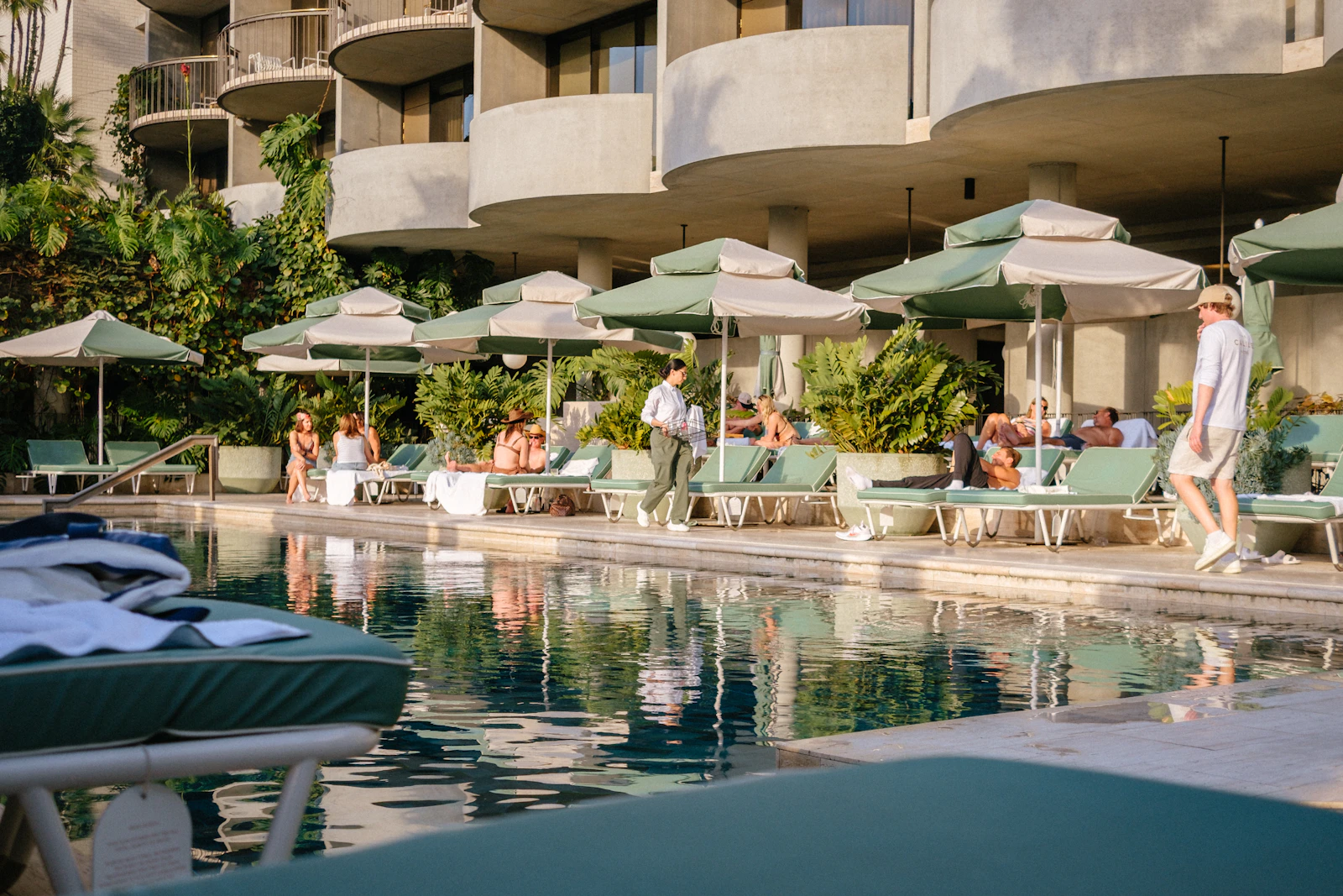 Luxury resort pool deck with slip-resistant aggregate flooring, tropical landscaping, and lounge chairs under Philippine sunlight